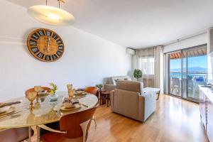 a living room with a table and a clock on the wall at UHC SANTILLANA FAMILY COMPLEX in Salou +33 photos