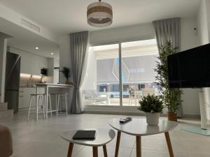 a living room with a kitchen and a large window at Beach House Costa Ballena in Chipiona