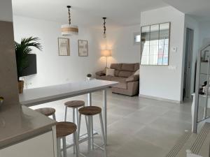 a kitchen and living room with a table and stools at Beach House Costa Ballena in Chipiona