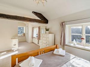 a bedroom with a bed and a dresser and windows at 3 Bed in Hawkshead 54193 in Hawkshead