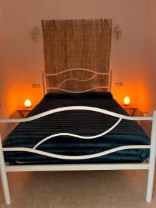 a bed with a black and white blanket on it at A Casinha in Carreira do Mato