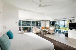 a bedroom with a large bed and a living room at Mangrove Hotel in Broome