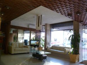 a living room with two couches and a tv at Punta del Este Shelton Hotel in Punta del Este