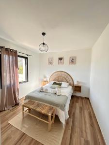 a white bedroom with a bed and a bench at Villa en Provence avec piscine in Mollégès +16 photos