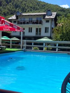 ein großer blauer Swimmingpool vor einem Gebäude in der Unterkunft Hotel Neron Bihać in Lohovo