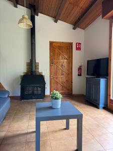a living room with a table and a wood stove at Racons del Pedraforca in Saldés