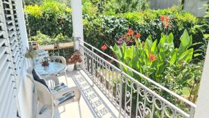 a balcony with a table and chairs and flowers at Apartman Stefan in Tivat