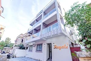 a white building with a sign on it at Hotel Royals in Rānchī
