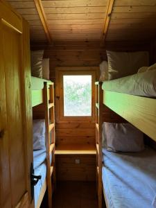 a small room with two bunk beds and a window at Racons del Pedraforca in Saldés