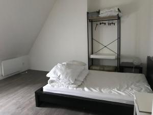 un lit défait dans une pièce avec une échelle dans l'établissement Triplex à 100m de la plage, à Dieppe