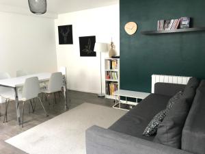 un salon avec un canapé et une table avec des chaises dans l'établissement Triplex à 100m de la plage, à Dieppe