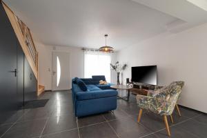 a living room with a blue couch and a table at Ma Bro - ERDIVINES in Erdeven