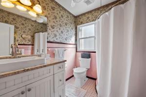 a pink bathroom with a sink and a toilet at Sunset Place in West Palm Beach +37 photos