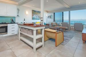 a kitchen with a island in the middle of a room at Walker Bay Luxury Seafront Apartment in Hermanus