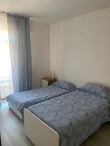a bedroom with two beds and a window at Casa Mattei in Chioggia