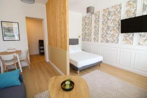 a living room with a bed and a table at G1 Appartement Familial lumineux RDC centre Angouleme in Angoulême