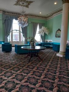 a room with a table and chairs and a chandelier at Royal Hotel in Scarborough
