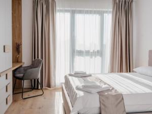 a bedroom with a bed and a chair and a window at DoubleS Maison 1 in Cluj-Napoca