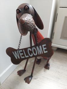 ReugnyにあるChez Barbouilleの床に歓迎のサインを持った犬の置物 +1枚の写真