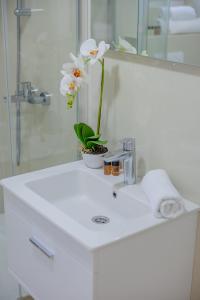 a bathroom sink with a vase of flowers on it at Bliss Apartments in Sutomore +49 photos