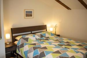 a bedroom with a bed with a colorful comforter at Borea Rooms - Sobe Budanje in Vipava