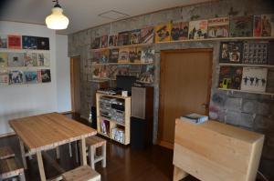 a room with a table and a table and a refrigerator at Guest House Isa in Motobu