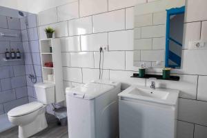 a white bathroom with a toilet and a sink at La Avenida Las Nieves Agaete in Puerto de las Nieves +56 photos