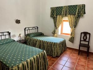 a bedroom with two beds and a window at Casa Rural Cortijo Torres in La Parra +25 photos
