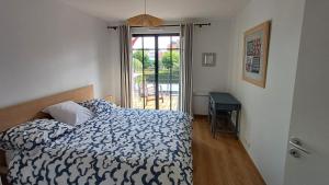 Un dormitorio con una cama y una puerta corrediza de vidrio. en Les Voiles du Clipper T2, en Préfailles 11 fotos más