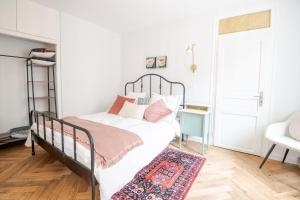 a bedroom with a black bed with a rug at Belle-Bleu Townhouse - Maison pour 8pers. in Amboise