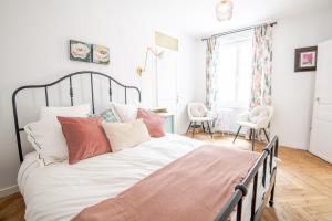 a bedroom with a large bed with pink and white pillows at Belle-Bleu Townhouse - Maison pour 8pers. in Amboise +8 photos