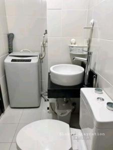 a small bathroom with a toilet and a sink at Kasara Urban Residences - Cozy Studio Unit in Manila