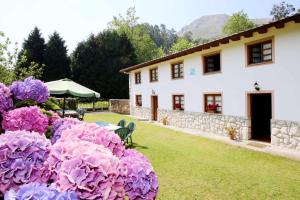 a house with purple flowers in the yard at Casa Vacacional el Molinin in Villanueva de Ardisana +41 photos