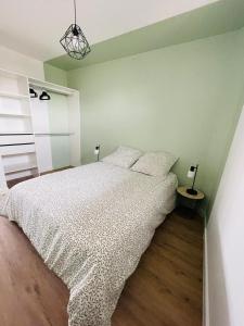 a bedroom with a bed with a white comforter at Verrières 2 in Issoire +1 photo