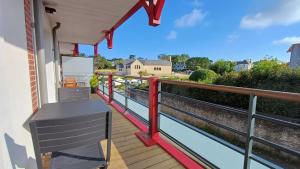 a porch with a bench on a deck at Les Voiles du Clipper T2 in Préfailles