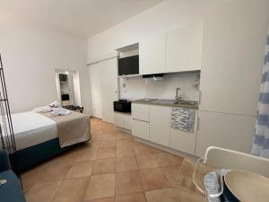a small room with a bed and a kitchen at Ostuni Ayla Apartments in Villanova di Ostuni