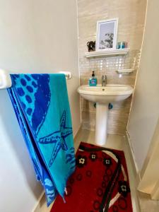 a bathroom with a sink and a towel on the floor at Luxe Home in Madinaty in Madinaty