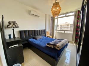 a bedroom with a blue bed and a window at Luxe Home in Madinaty in Madinaty +10 photos