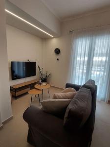 un soggiorno con divano e TV a schermo piatto di Urban Escape ad Atene