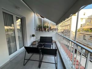 un balcone con tre sedie e finestre su un edificio di Urban Escape ad Atene