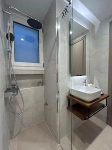 un bagno bianco con lavandino e doccia di Urban Escape ad Atene Altre 11 foto