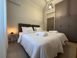 una camera da letto con due letti con lenzuola bianche di Urban Escape ad Atene