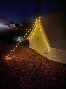 a tent with lights on the ground at night at Country View Camping in Bratton