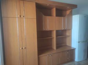 a kitchen with wooden cabinets and a refrigerator at Navy Sky View - Garsoniera confort I in Tulcea