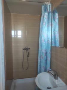 a shower with a blue shower curtain and a sink at Navy Sky View - Garsoniera confort I in Tulcea