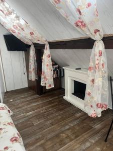 a room with a bed and a fireplace with curtains at Dziupla in Wygiełzów