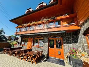 a restaurant with wooden tables and benches in front of it at Penzión Patrik in Ždiar