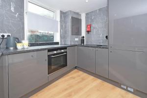 una cocina con electrodomésticos de acero inoxidable y una ventana en Richard Moon House - By Sigma Stays, en Crewe