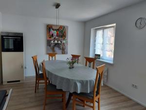 a dining room with a table and chairs and a clock at Ferienwohnung Josy in Memmelsdorf