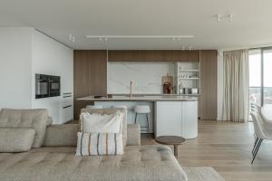 a living room with a couch and a kitchen at Enso District Residences in Knokke-Heist